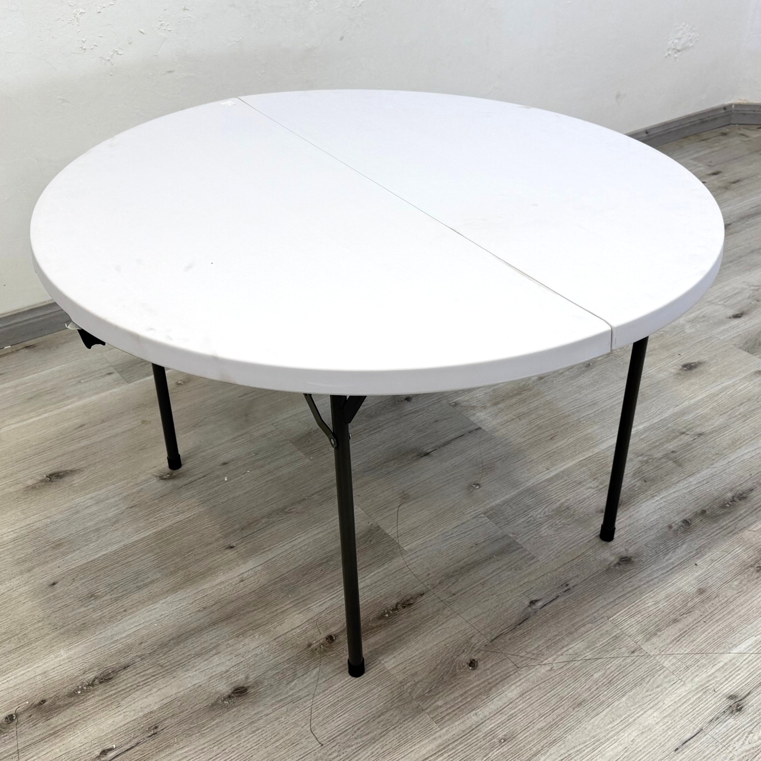 Peak 1.2m round outdoor folding table with white plastic top and metal legs